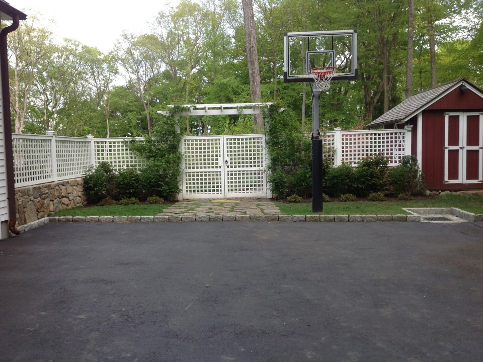 Sports court and fieldstone wall with fence, gate, arbor and plantings